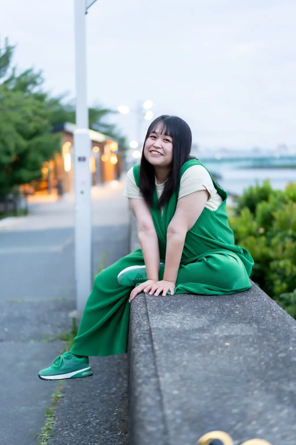 緑の服を着て笑顔で座る松田恵里加